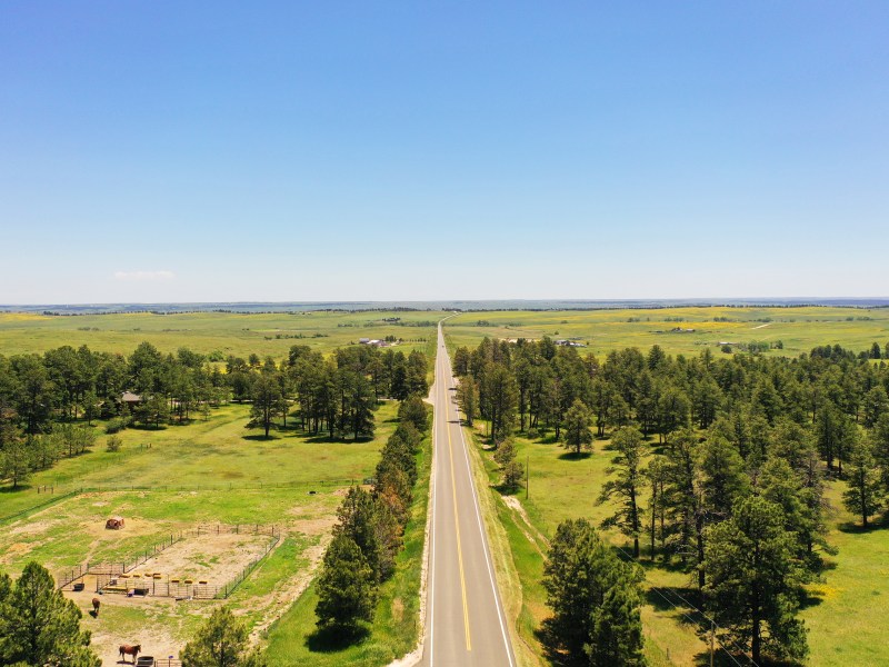 A drone shot of vast, green ranchland with a state highway cutting through the middle near where Segment 5 of Power Pathway will be built.