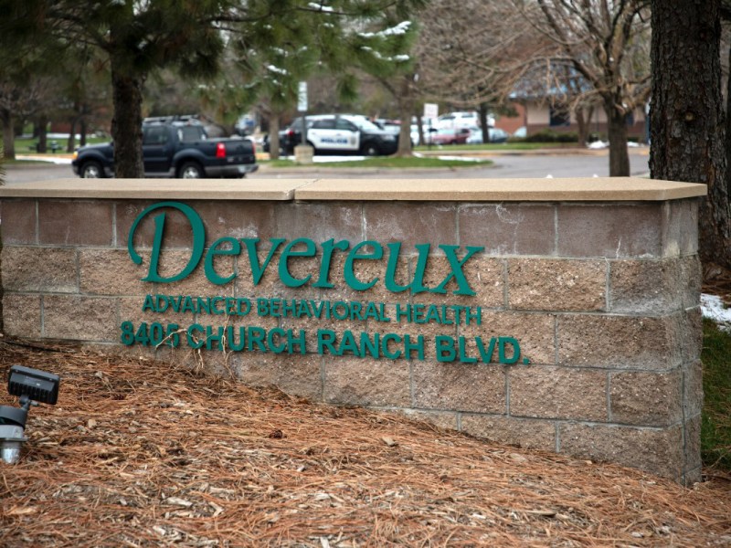A sign outside a parking lot to a building says "Devereux"